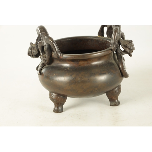 241 - A CHINESE PATINATED BRONZE CENSER WITH DRAGON HANDLES of squat bulbous form raised on shaped legs, i... 