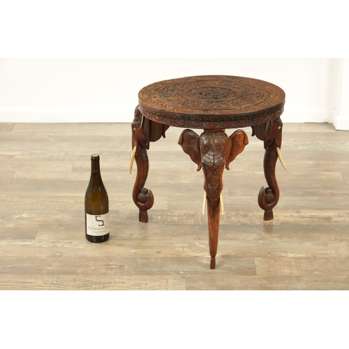 245 - A 19TH CENTURY INDIAN CARVED HARDWOOD OCCASIONAL TABLE the circular carved top above three elephant'... 