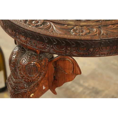 245 - A 19TH CENTURY INDIAN CARVED HARDWOOD OCCASIONAL TABLE the circular carved top above three elephant'... 