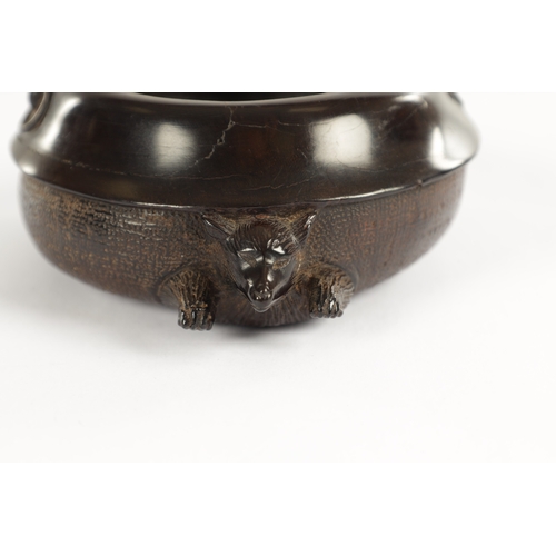 250 - A JAPANESE MEIJI PERIOD CARVED HARDWOOD BRUSH POT of shallow circular form modelled as a recumbent f... 