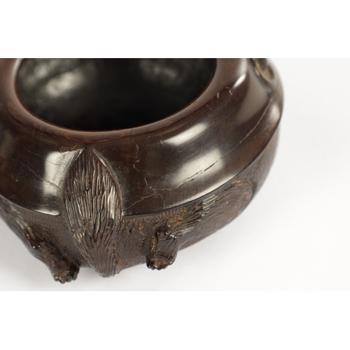 250 - A JAPANESE MEIJI PERIOD CARVED HARDWOOD BRUSH POT of shallow circular form modelled as a recumbent f... 