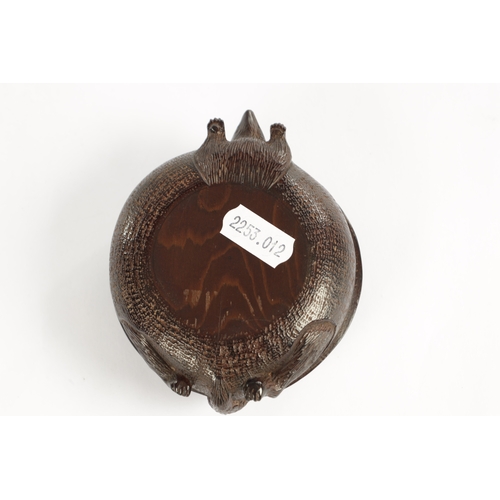 250 - A JAPANESE MEIJI PERIOD CARVED HARDWOOD BRUSH POT of shallow circular form modelled as a recumbent f... 