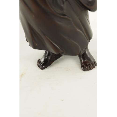 275 - A 19TH CENTURY JAPANESE CARVED HARDWOOD OKIMONO modelled as a standing Buddha, four character signat... 