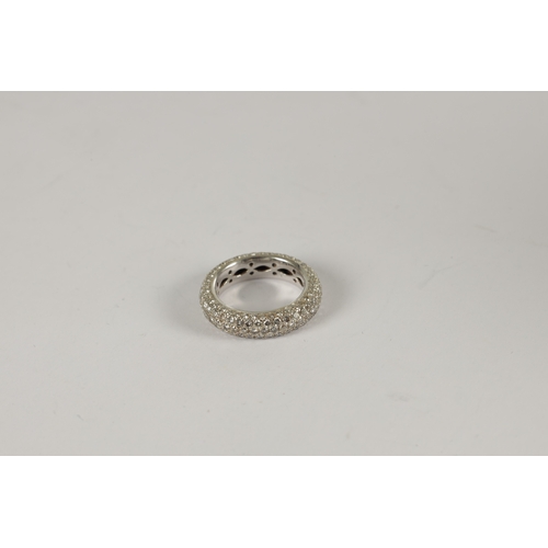 304 - A LADIES' WHITE GOLD AND DIAMOND ETERNITY RING diamond encrusted all over, the shank pierced to the ... 