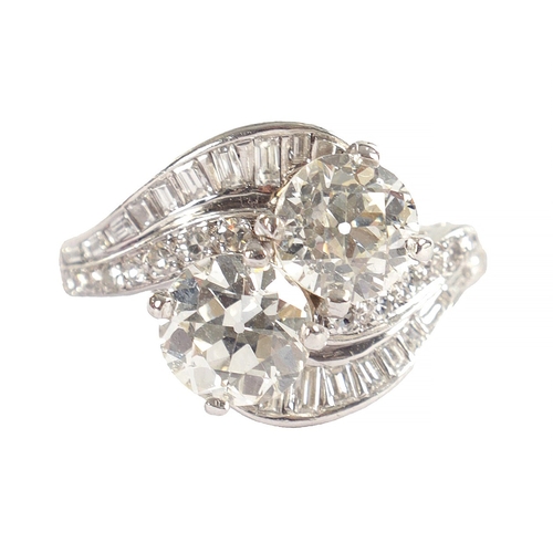 346 - A FINE PLATINUM SET CROSS-OVER TWO-STONE DIAMOND RING with twisted shoulders, each channel set with ... 