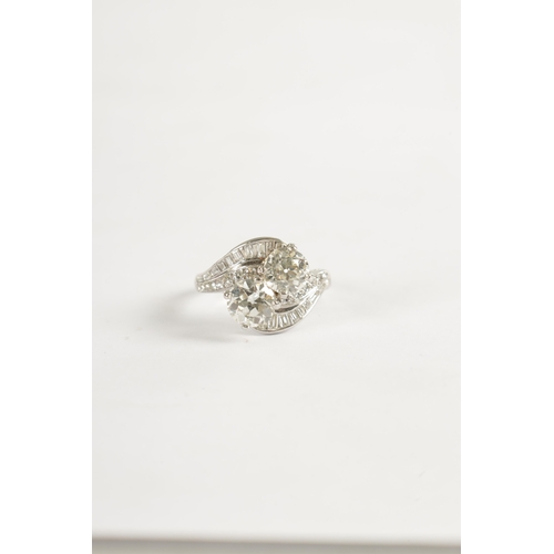 346 - A FINE PLATINUM SET CROSS-OVER TWO-STONE DIAMOND RING with twisted shoulders, each channel set with ... 