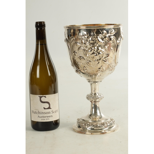 405 - A VICTORIAN GIANT SIZE SILVER GOBLET of impressive design with deeply embossed flowerhead and leafwo... 