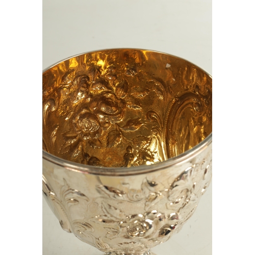 405 - A VICTORIAN GIANT SIZE SILVER GOBLET of impressive design with deeply embossed flowerhead and leafwo... 