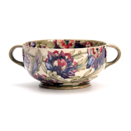 41 - A WILLIAM MOORCROFT BURSLEM FOOTED TWO-HANDLED BOWL with colourful tube lined flowerhead and leaf sp... 