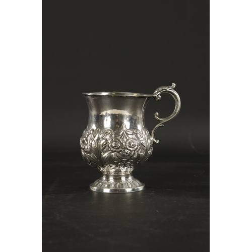 413 - AN IRISH FLORAL EMBOSSED SILVER CHRISTENING MUG, with scroll handle and raised on circular foot. - 1... 