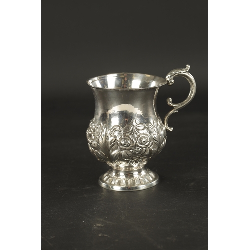 413 - AN IRISH FLORAL EMBOSSED SILVER CHRISTENING MUG, with scroll handle and raised on circular foot. - 1... 