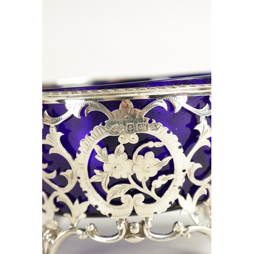 415 - A VICTORIAN SILVER BASKET WITH BLUE GLASS LINER with scrolled open leafwork body, hatched, flowerhea... 