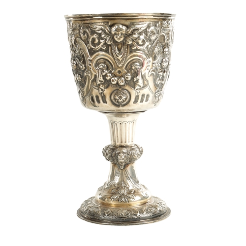 418 - A GEORGE III GIANT-SIZE SILVER GOBLET the body deeply embossed with winged cherub heads, leafing fru... 