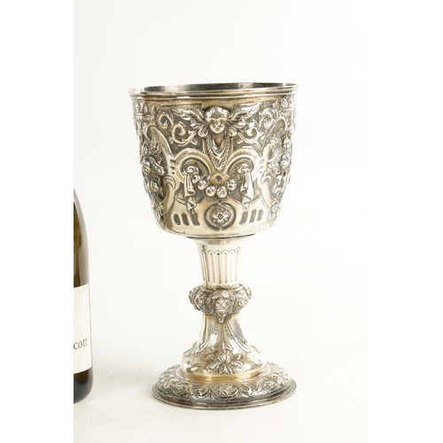 418 - A GEORGE III GIANT-SIZE SILVER GOBLET the body deeply embossed with winged cherub heads, leafing fru... 