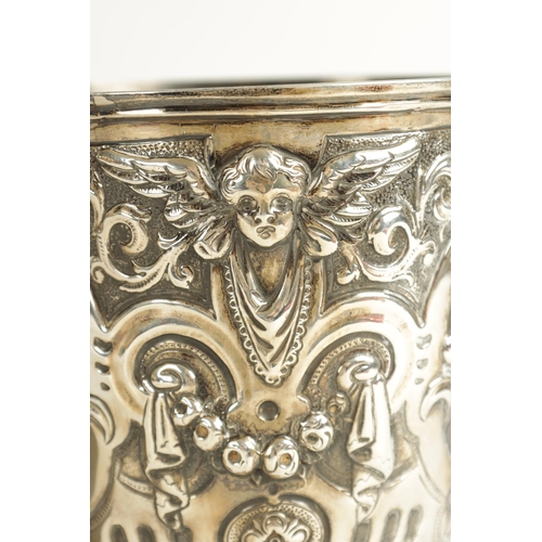 418 - A GEORGE III GIANT-SIZE SILVER GOBLET the body deeply embossed with winged cherub heads, leafing fru... 