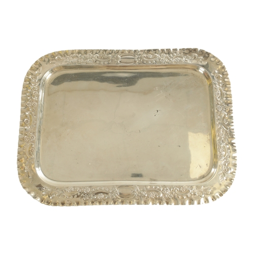 442 - AN EDWARD VII SILVER RECTANGULAR TRAY with florally embossed scroll work crimped border and plain ce... 