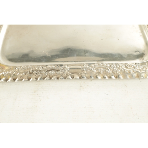 442 - AN EDWARD VII SILVER RECTANGULAR TRAY with florally embossed scroll work crimped border and plain ce... 