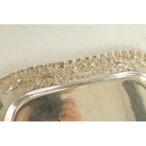 442 - AN EDWARD VII SILVER RECTANGULAR TRAY with florally embossed scroll work crimped border and plain ce... 