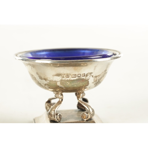 443 - A PAIR OF SILVER SALT CELLARS WITH BLUE GLASS LINERS, raised on scrolled supports and square moulded... 