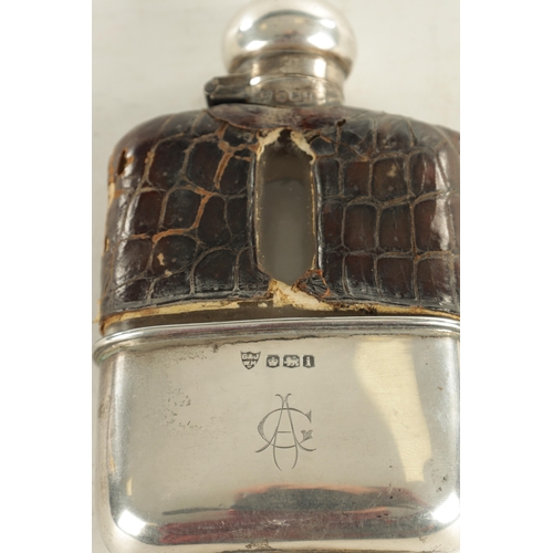 458 - A SMALL EARLY 20TH CENTURY SILVER MOUNTED CROCODILE SKIN HIP FLASK the glass body with hinged bayone... 