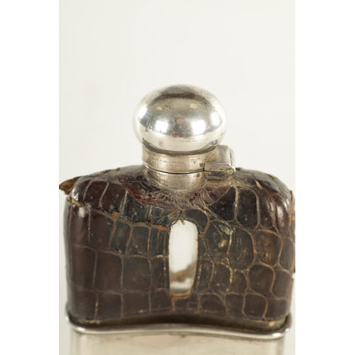 458 - A SMALL EARLY 20TH CENTURY SILVER MOUNTED CROCODILE SKIN HIP FLASK the glass body with hinged bayone... 