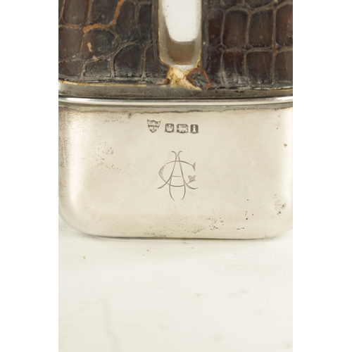 458 - A SMALL EARLY 20TH CENTURY SILVER MOUNTED CROCODILE SKIN HIP FLASK the glass body with hinged bayone... 