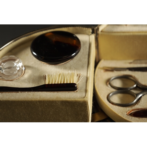 471 - LARGE OVAL SILVER MOUNTED TORTOISESHELL MANICURE SET, of oval form with hinged lid and front opening... 