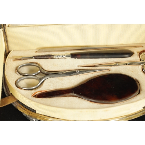 471 - LARGE OVAL SILVER MOUNTED TORTOISESHELL MANICURE SET, of oval form with hinged lid and front opening... 