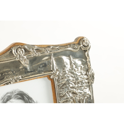 475 - AN UNUSUAL ART NOUVEAU PERIOD SILVER PICTURE FRAME, having repousse decoration depicting the Native ... 