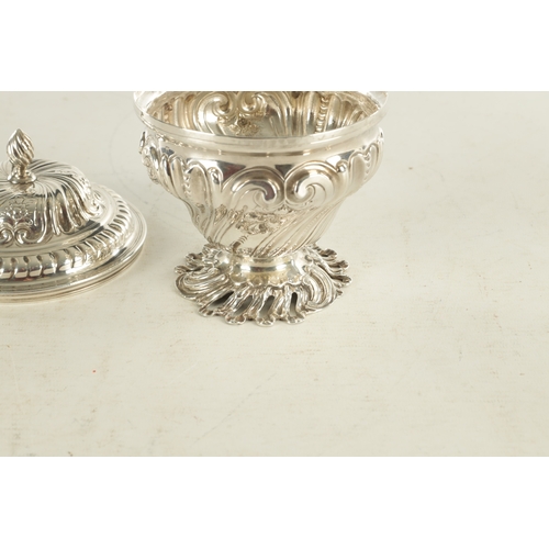 480 - A GEORGE III ROCOCO STYLE SILVER SUGAR BOWL AND COVER decorated with scrolling floral work standing ... 