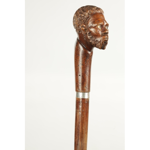 496 - A COLLECTION OF THREE LATE 19TH CENTURY CARVED WOOD MASK HEAD WALKING STICKS one with silver collar ... 