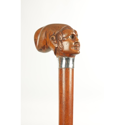 496 - A COLLECTION OF THREE LATE 19TH CENTURY CARVED WOOD MASK HEAD WALKING STICKS one with silver collar ... 