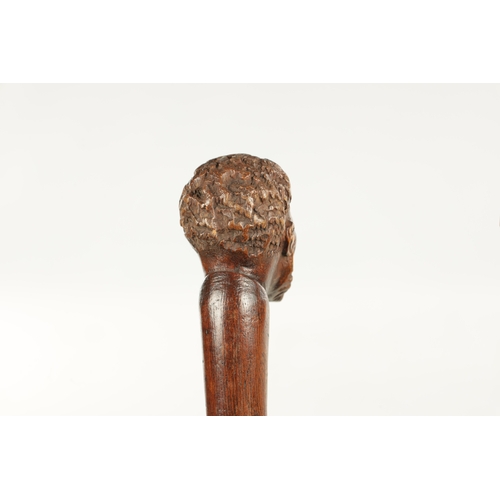 496 - A COLLECTION OF THREE LATE 19TH CENTURY CARVED WOOD MASK HEAD WALKING STICKS one with silver collar ... 