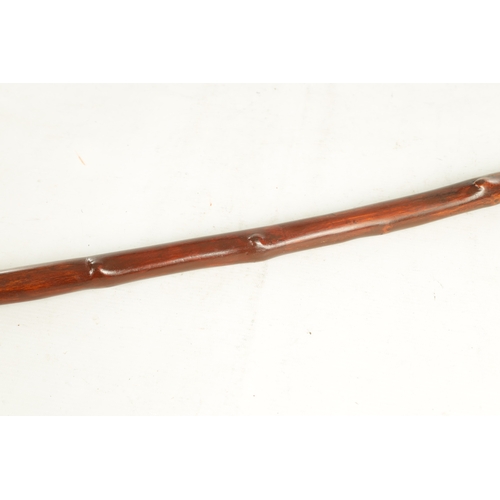 509 - AN EARLY 19TH CENTURY FOLK ART CARVED WALKING STICK the stained branch work shaft with a carved man'... 