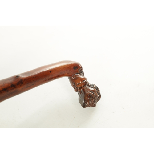 509 - AN EARLY 19TH CENTURY FOLK ART CARVED WALKING STICK the stained branch work shaft with a carved man'... 