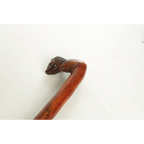 509 - AN EARLY 19TH CENTURY FOLK ART CARVED WALKING STICK the stained branch work shaft with a carved man'... 