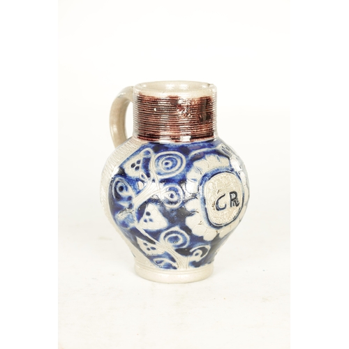 66 - A 19TH CENTURY WESTERWALD GERMAN STONEWARE JUG with blue highlighted incised floral decorations encl... 