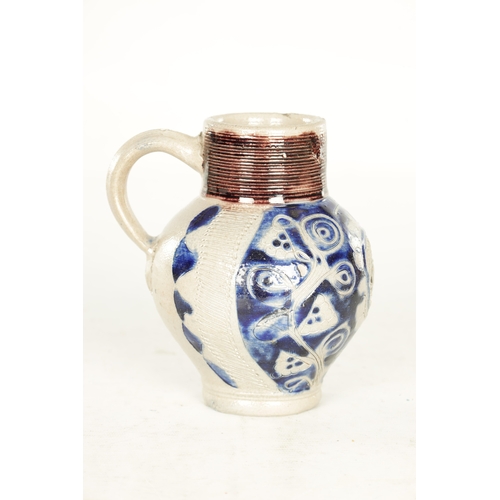 66 - A 19TH CENTURY WESTERWALD GERMAN STONEWARE JUG with blue highlighted incised floral decorations encl... 