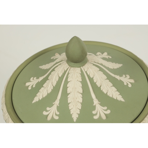 67 - A LATE 20TH CENTURY WEDGWOOD PALE GREEN JASPER WARE TWO-HANDLED PEDESTAL URN SHAPED VASE AND COVER o... 