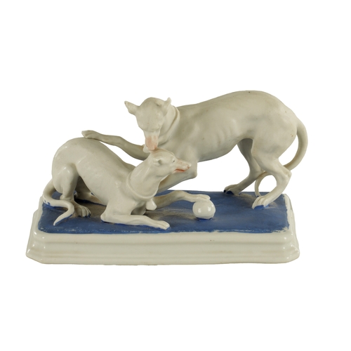 71 - A LATE 19TH CENTURY GERMAN BISQUE PORCELAIN SCULPTURE OF TWO WHIPPETS PLAYING on a blue moulded base... 