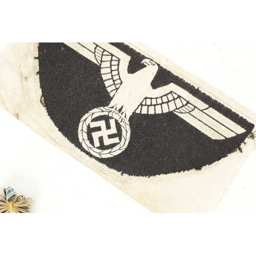 547 - THREE WWII GERMAN NAZI MEDALS AND AN EMBROIDERED INSIGNIA the medals comprising of an enamel Hitler ... 