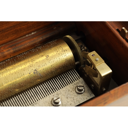 575 - A 19TH CENTURY SWISS MUSIC BOX having walnut case enclosing an early music box playing six airs bear... 