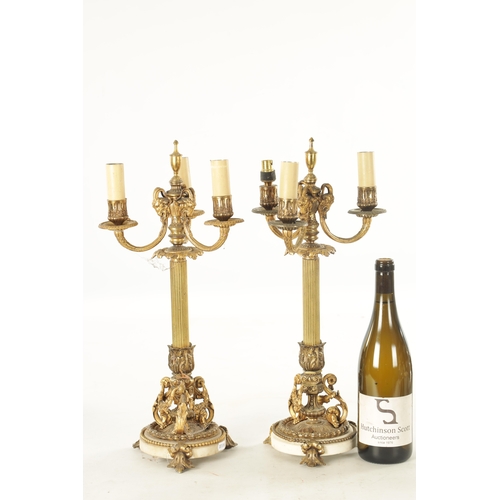 599 - A PAIR OF LATE 19TH CENTURY FRENCH ORMOLU AND WHITE MARBLE THREE BRANCH CANDELABRA with ram's head m... 