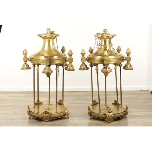 604 - A LARGE PAIR OF EDWARDIAN GILT BRASS HANGING LANTERNS with shaped tops and pineapple finials each ha... 