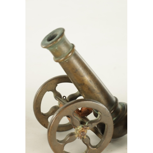 607 - A 19TH CENTURY BRONZE MODEL OF A STARTER CANNON on cast brass carriage TOGETHER WITH A CAST IRON STA... 