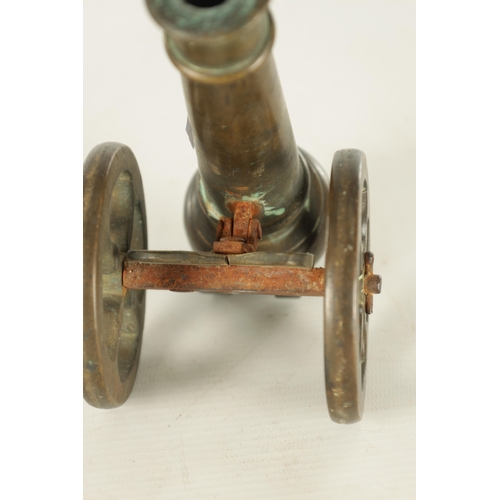 607 - A 19TH CENTURY BRONZE MODEL OF A STARTER CANNON on cast brass carriage TOGETHER WITH A CAST IRON STA... 