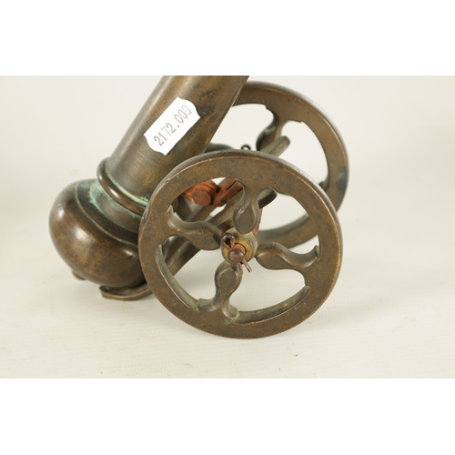 607 - A 19TH CENTURY BRONZE MODEL OF A STARTER CANNON on cast brass carriage TOGETHER WITH A CAST IRON STA... 