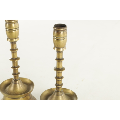 625 - A PAIR OF 20TH CENTURY EARLY DUTCH STYLE BRASS CANDLESTICKS having knopped stems and dished bases (2... 