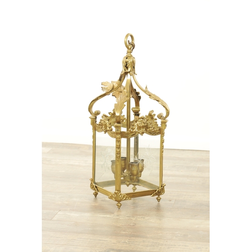 632 - A LATE 19TH CENTURY GILT BRASS SQUARE HANGING LANTERN with acanthus leaf shaped arms above masked ri... 