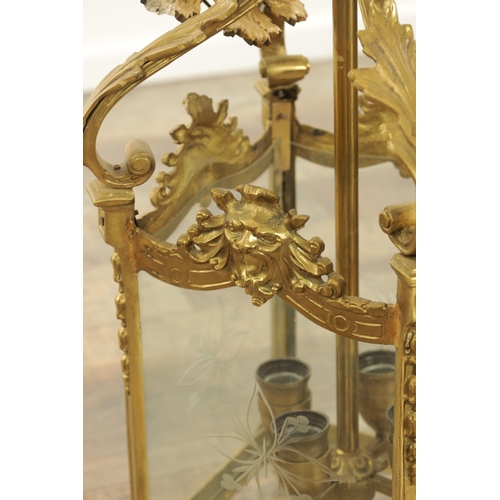 632 - A LATE 19TH CENTURY GILT BRASS SQUARE HANGING LANTERN with acanthus leaf shaped arms above masked ri... 